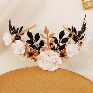 Detail view of handmade Halloween headband with white roses, black leaves, and gold branches