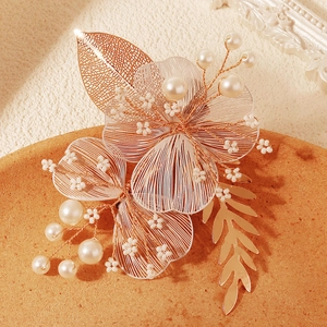Pince à cheveux de mariée avec pétales en fil doré et perles sur fond texturé élégant