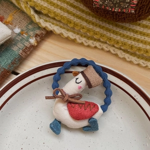 Détail d'élastique à cheveux bleu ondulé avec décor de petit oie en tissu blanc