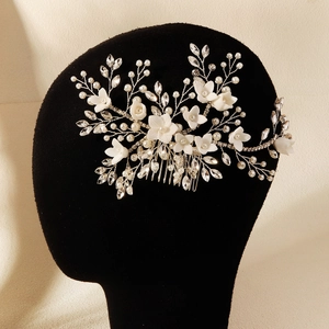 Close-up of handmade bridal hair comb with ceramic flowers and sparkling crystals