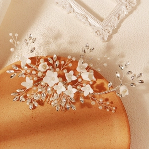 Handmade bridal hair comb with pearls, ceramic flowers and crystals on a clay tray