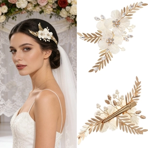 Détail de la pince à cheveux de mariée avec fleurs blanches et feuilles dorées à perles