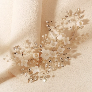 Detail of handmade bridal hair comb with white flowers, crystals, and pearls on silver wire
