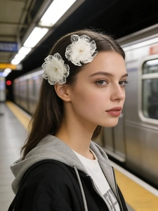 Dettaglio di fermagli per capelli con fiori in tulle bianco e perle per acconciature