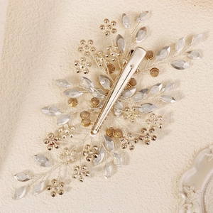 Handmade bridal hair clip with silver wire leaves and rhinestones on a metal duckbill clip