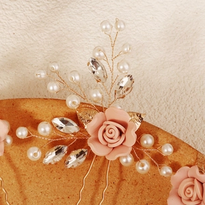 Détail d'épingle à cheveux de mariée avec roses roses, perles et vigne en fil doré