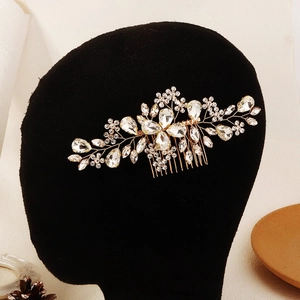 Détail du peigne à cheveux mariée avec fleurs en cristal et feuilles dorées sur velours