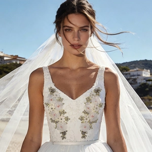 Close-up of intricate 3D floral embroidery and beaded sequins on white V-neck bridal gown