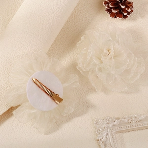 Vista dettagliata delle fermagli per capelli in tulle bianco con perle e base a becco d'anatra