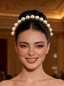 Front close-up of a luxury French style headband with 13 large cream pearls on a gold frame