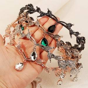 Detailed close-up of alloy crowns with leaf branch motifs and teardrop rhinestone pendants