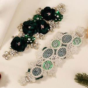 Detailed back view of a dark green fabric flower brooch with rhinestones and pin