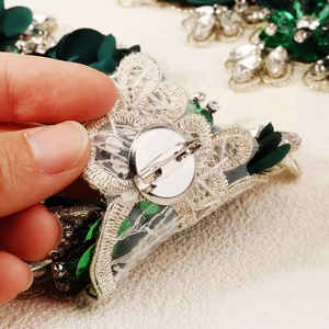 Close-up of the silver metal safety pin fastener on the back of the fabric flower brooch