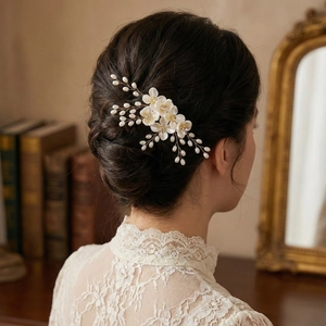 Dettaglio del pettine per capelli con fiori di acrilico, perle e fili dorati