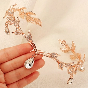 Close-up of rose gold leaf tiara with sparkling rhinestones and drop crystal pendants