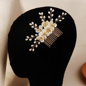Dettaglio del pettine per capelli fatto a mano con fiori di acrilico, perle e fili dorati