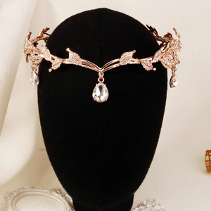 Macro detail of rose gold bridal crown featuring crystal leaves and pear-shaped pendants