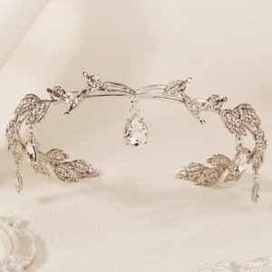 Macro shot of silver bridal crown with rhinestone leaves and teardrop pendant detail