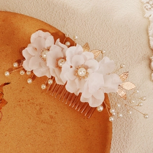 Close-up of handmade bridal hair comb with fabric flowers, pearls and golden leaves