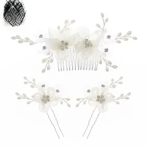 Close-up of bridal hair comb set with white ceramic flowers and crystal pearls