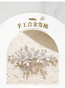 Dettaglio del pettine da sposa fatto a mano con foglie in lega e fiori di strass luccicanti