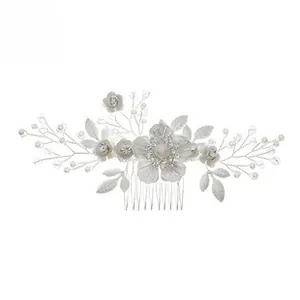 Detail showing bridal hair comb with silver leaves, white fabric flowers, and pearls