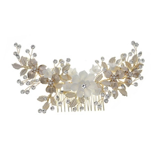 Detail of floral bridal hair comb with white flowers, gold leaves and rhinestones