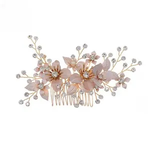 Detail of pink fabric flowers and sparkling rhinestones on a gold bridal hair comb