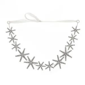 Detail of snowflake rhinestone bridal headband with white ribbon ties on white background
