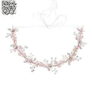 Detail of rose gold bridal headband with pink flowers, white pearls, and crystals