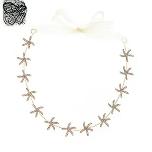 Detail of golden starfish headband with tiny white rhinestones and sheer ribbon tie