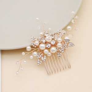 Détail d'un peigne de mariée avec fil d'or, perles blanches et feuilles de cristal
