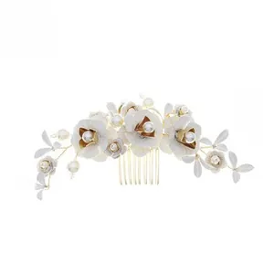 Macro detail of bridal hair comb featuring white flowers, pearls and golden metallic base