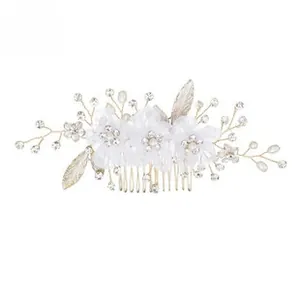 Détail d'un peigne de mariée fait main avec fleurs en soie, perles et feuilles dorées