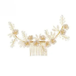 Detail of bridal hair comb with acrylic flowers, pearls, and gold wire floral clusters