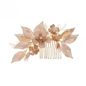 Detailed close-up of champagne acrylic flowers and pearls on a gold bridal hair comb