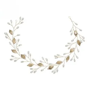 Detail of handcrafted gold bridal headband with metallic leaves and white faux pearls