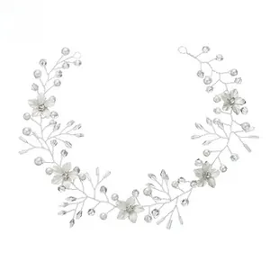 Macro detail of handmade silver bridal hair vine with white flowers, pearls and crystals