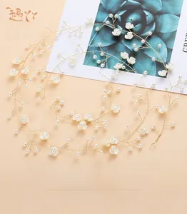 Detail of handmade bridal headband with gold wires, white flowers and pearls