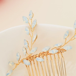 Close-up of gold wire bridal hair comb with light blue opal stones and leaves
