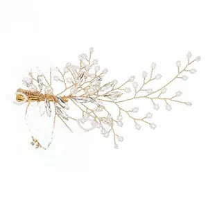 Close-up of handmade bridal hair clip with gold floral vines, pearls and rhinestones