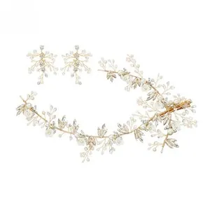 Detail of handmade gold bridal headpiece with white flowers, pearls and crystal earrings