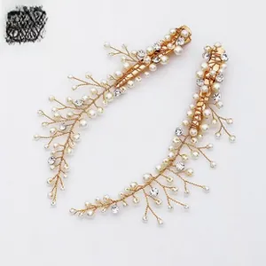 Detailed view of handmade bridal hair clips with white pearls and crystals on gold wire