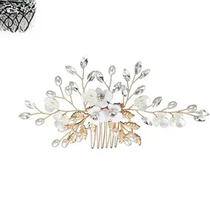 Détail du peigne à cheveux de mariée avec fleurs blanches, perles et cristaux dorés
