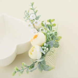 Détails macro d'un peigne à cheveux de mariée avec roses jaunes et muguet blanc fait main