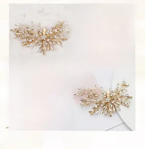 Detail view of handmade bridal hair clip with gold wire leaves and sparkling rhinestones
