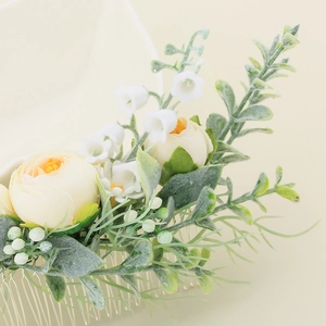 Détail macro du peigne à cheveux pour mariée avec pivoines crème et feuilles