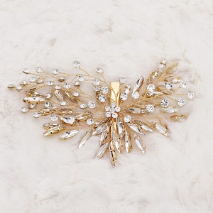 Handmade bridal hair clip with gold leaf design and sparkling rhinestones for weddings