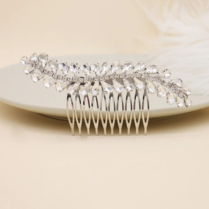 Dettaglio del pettine da sposa con strass eleganti su un vassoio di ceramica bianca