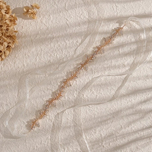 Elegant bridal headpiece with gold leaf design and rhinestones featuring white silk ribbons